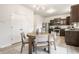 Bright dining area featuring a modern chandelier, dining table with four chairs, and ample storage with stainless steel appliances at 647 Albermarle Dr, Pittsboro, IN 46167