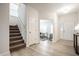 Bright and airy entryway with light wood flooring, a staircase, and a view into an office space with neutral decor at 647 Albermarle Dr, Pittsboro, IN 46167