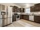 Modern kitchen with stainless steel appliances, granite countertops, and wood-look floors at 647 Albermarle Dr, Pittsboro, IN 46167