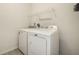 Clean, organized laundry room with modern washer and dryer, and overhead shelving at 647 Albermarle Dr, Pittsboro, IN 46167