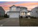 Charming two-story home featuring a two-car garage, covered porch with seating, and well-maintained landscaping at 6630 Overlander Ln, Whitestown, IN 46075
