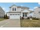 Charming two-story home featuring a two-car garage, covered porch with seating, and well-maintained landscaping at 6630 Overlander Ln, Whitestown, IN 46075