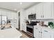 Bright kitchen with stainless steel appliances, white cabinets, and ample counter space for cooking at 6630 Overlander Ln, Whitestown, IN 46075