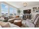 Bright living room featuring a large sectional sofa, media center, and large windows with neighborhood views at 6630 Overlander Ln, Whitestown, IN 46075