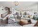 Open-concept layout showcases a living room with a comfortable sectional, ottoman, and an adjacent staircase and kitchen at 6630 Overlander Ln, Whitestown, IN 46075