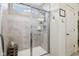 Tiled shower with glass door with built-in shower caddy and neutral walls and flooring at 6630 Overlander Ln, Whitestown, IN 46075