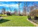 Well-manicured backyard with lush green lawn, mature trees, and landscaping at 6820 W Forest Brook Dr, Fountaintown, IN 46130