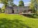 Spacious backyard featuring a well-maintained lawn, mature trees, and a deck at 6820 W Forest Brook Dr, Fountaintown, IN 46130