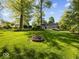 Expansive backyard with firepit, landscaping, and mature trees at 6820 W Forest Brook Dr, Fountaintown, IN 46130