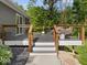 View of outdoor deck featuring outdoor seating, wood railing, and decorative stone at 6820 W Forest Brook Dr, Fountaintown, IN 46130