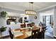 Well-lit dining room featuring a modern chandelier, a wooden dining table set, and views into the kitchen at 6820 W Forest Brook Dr, Fountaintown, IN 46130