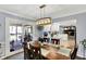 Dining room with a wood table, chairs, a modern chandelier, and access to the screened-in back porch at 6820 W Forest Brook Dr, Fountaintown, IN 46130
