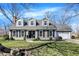 Charming two-story home with gray siding, black shutters, manicured lawn, and beautiful landscaping at 6820 W Forest Brook Dr, Fountaintown, IN 46130