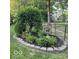 Well-maintained flowerbed with lush greenery, flowers, and a garden decoration at 6820 W Forest Brook Dr, Fountaintown, IN 46130