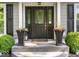 Inviting front entryway with a black door, decorative planters, and a welcome mat at 6820 W Forest Brook Dr, Fountaintown, IN 46130