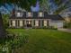 Charming home featuring a manicured lawn, gray siding, dormer windows, and a two-car garage at 6820 W Forest Brook Dr, Fountaintown, IN 46130