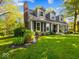 Charming home with a manicured lawn, dormer windows, gray siding, and a brick chimney at 6820 W Forest Brook Dr, Fountaintown, IN 46130