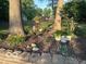 Landscaped flowerbed with brick border, mature trees, and hanging planters at 6820 W Forest Brook Dr, Fountaintown, IN 46130