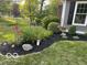 Landscaped flower bed with mulch, a variety of plantings, and a trimmed shrub at 6820 W Forest Brook Dr, Fountaintown, IN 46130