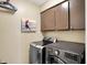 Functional laundry room featuring modern washer and dryer units and upper cabinets for storage at 6820 W Forest Brook Dr, Fountaintown, IN 46130