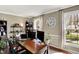 Bright home office with two large windows, wooden desk, shelves, and wood flooring at 6820 W Forest Brook Dr, Fountaintown, IN 46130