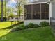 Backyard view of screened porch that adjoins an outdoor deck and professionally landscaped yard at 6820 W Forest Brook Dr, Fountaintown, IN 46130