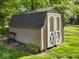 Backyard shed with double doors, a bench, and manicured lawn at 6820 W Forest Brook Dr, Fountaintown, IN 46130