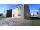 View of the home's rear exterior showcasing the siding, windows, and sliding glass door to the backyard at 735 Locust Dr, Danville, IN 46122