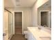 Well-lit bathroom with double sinks, quartz countertops, and a glass shower, and access to a walk-in closet at 735 Locust Dr, Danville, IN 46122