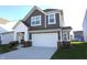 Charming two-story home featuring a two-car garage, gray siding, white trim, and a well-manicured lawn at 735 Locust Dr, Danville, IN 46122