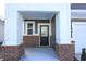 Inviting covered front porch with brick columns and a stained-glass front door at 735 Locust Dr, Danville, IN 46122