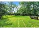 Expansive backyard offering lush green grass and mature trees, perfect for outdoor activities and relaxation at 8315 San Marcos Cir, Indianapolis, IN 46256