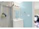 A clean bathroom featuring a white vanity, circular mirror, and a glass door shower with modern fixtures at 8315 San Marcos Cir, Indianapolis, IN 46256