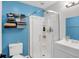 A compact full bathroom featuring a shower with glass door, toilet, storage shelving and sink with vanity at 8315 San Marcos Cir, Indianapolis, IN 46256