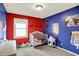A bright, colorful bedroom with red and blue walls and Spiderman decorations at 8315 San Marcos Cir, Indianapolis, IN 46256