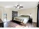 A spacious bedroom featuring hardwood floors, neutral walls, and a ceiling fan above a comfortably made queen bed at 8315 San Marcos Cir, Indianapolis, IN 46256