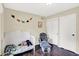 A bright Bedroom with a white crib, plush glider, and charming dinosaur decorations on the walls at 8315 San Marcos Cir, Indianapolis, IN 46256