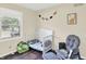 A bright Bedroom with a white crib, plush glider, and charming dinosaur decorations on the walls at 8315 San Marcos Cir, Indianapolis, IN 46256