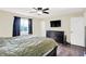 A cozy bedroom featuring hardwood floors, a wall-mounted television, a dresser and a bright window at 8315 San Marcos Cir, Indianapolis, IN 46256