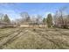 Expansive backyard with a home's tan exterior, deck, and surrounding trees at 8606 Manderley Dr, Indianapolis, IN 46240