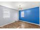Bedroom with two windows, hardwood floors, and a blue accent wall at 8606 Manderley Dr, Indianapolis, IN 46240