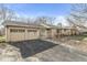 View of the two-car garage and entrance of a single-story home with an asphalt driveway at 8606 Manderley Dr, Indianapolis, IN 46240