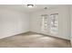 Bright, carpeted bedroom with white walls and a glass door leading to the outside at 8920 Hunters Creek Dr # 101, Indianapolis, IN 46227