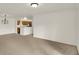 Open-concept living room featuring neutral carpeting and a glimpse into the kitchen at 8920 Hunters Creek Dr # 101, Indianapolis, IN 46227
