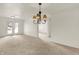 Bright living area featuring carpet floors, French doors, and a decorative chandelier at 8920 Hunters Creek Dr # 101, Indianapolis, IN 46227