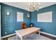 Stylish office space with wood desk, designer lighting, blue accent wall and neutral rug at 950 Edmonds Pl, Greenwood, IN 46143