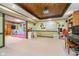 Spacious finished basement with wood-trimmed ceiling, carpet, an adjacent playroom area with padding, and built-in bookcase at 10937 Sawgrass Dr, Fishers, IN 46037