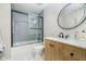 Modern bathroom featuring a tiled shower with sliding glass door, a vanity with round mirror, and hexagon tile flooring at 10937 Sawgrass Dr, Fishers, IN 46037