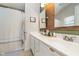 Well-lit bathroom features double sinks, a large mirror, and a shower-tub combination with curtain at 10937 Sawgrass Dr, Fishers, IN 46037