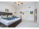 Spacious main bedroom with ceiling fan, ensuite access, and a large bed with dark wood frame at 10937 Sawgrass Dr, Fishers, IN 46037